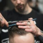 Man Cutting the Hair on the Person Sitting on the Chair